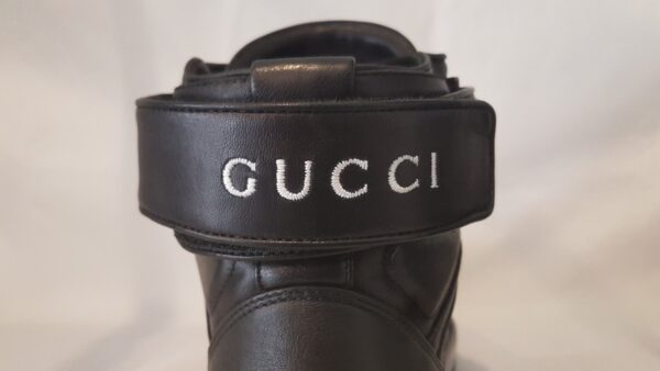 Luxurious pre-owned Gucci high top trainers in black leather with logo embroidery. Includes box and dust bag.